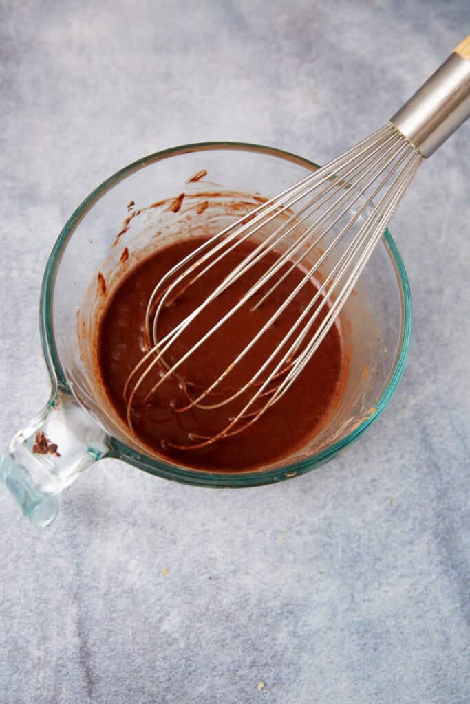 German chocolate cake batter smoothed into two round cake pans before baking.