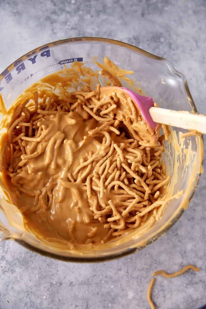 Chow mein noodles folded into the melted white chocolate, butterscotch, and peanut butter mixture for haystack cookies.