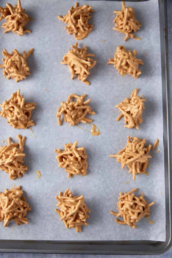 Haystack cookies scooped onto a parchment-lined baking sheet before setting.