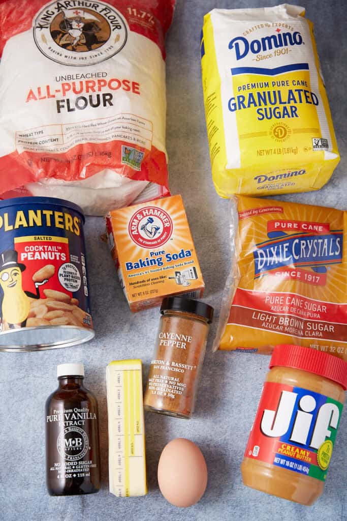 Dry ingredients for peppery peanut butter cookies whisked together in a white mixing bowl with cayenne pepper nearby.