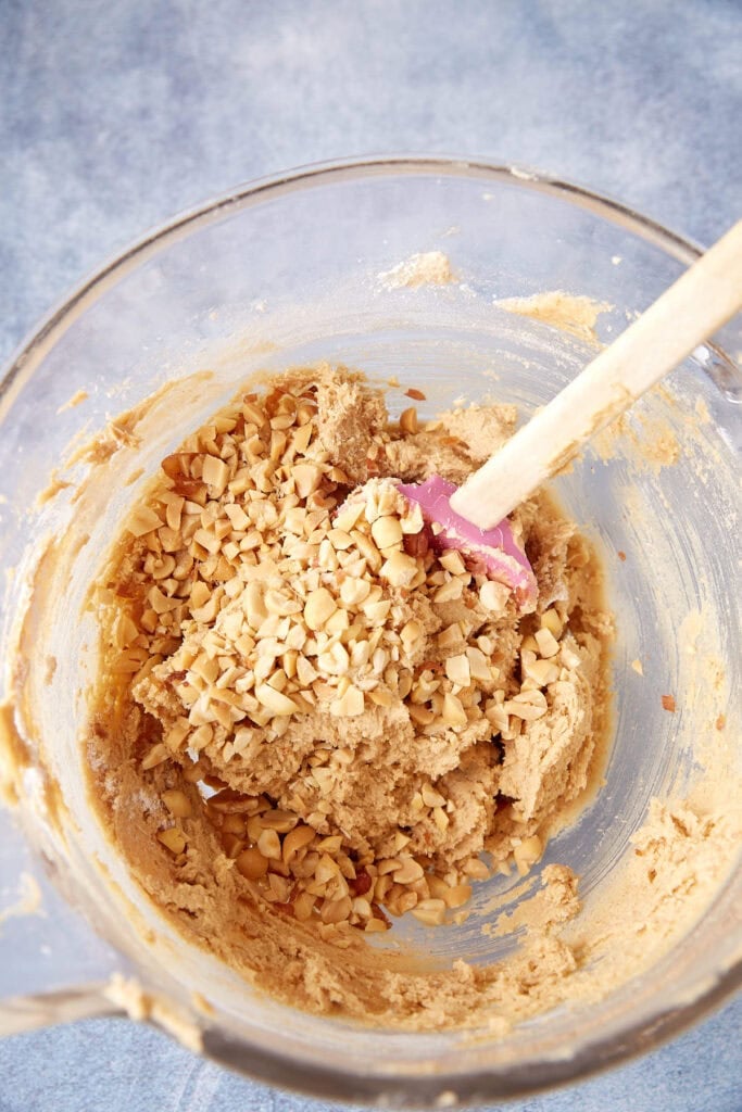 Peanut butter cookie dough after mixing in the wet ingredients, smooth and creamy in a glass bowl.