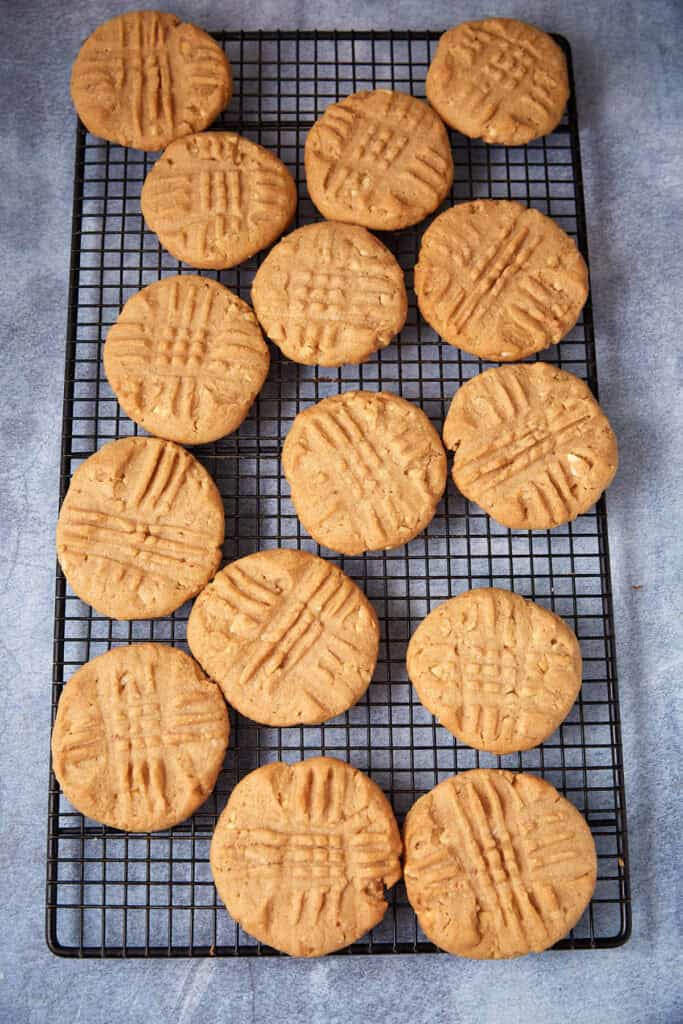 Baked peppery peanut butter cookies cooling on a wire rack.