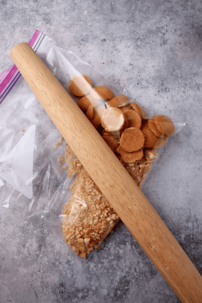 Vanilla wafers being crushed with a rolling pin.