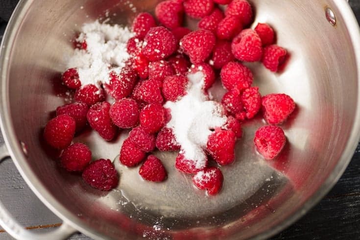Fresh raspberries, sugar, and cornstarch in a saucepan for homemade raspberry jam.