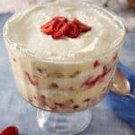 Strawberry trifle layered with biscuits, vanilla custard, strawberries, and whipped cream.