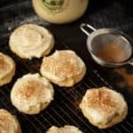 A wire rack with eggnog cookies sprinkled with cinnamon.
