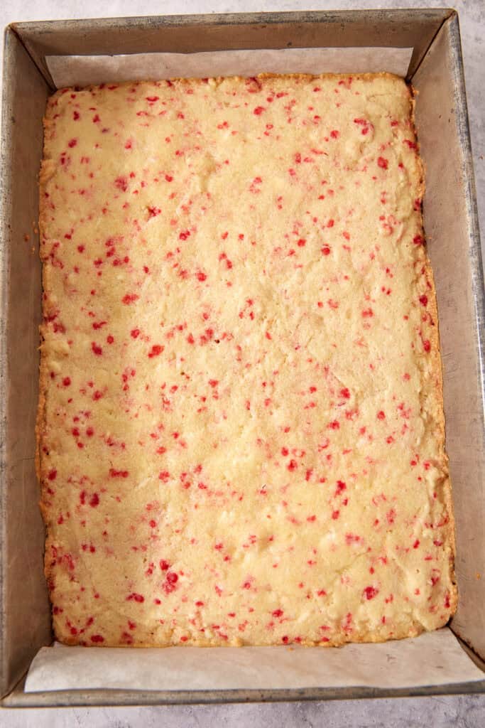 A rectangular pan of baked cookie bars sprinkled with red candy bits.